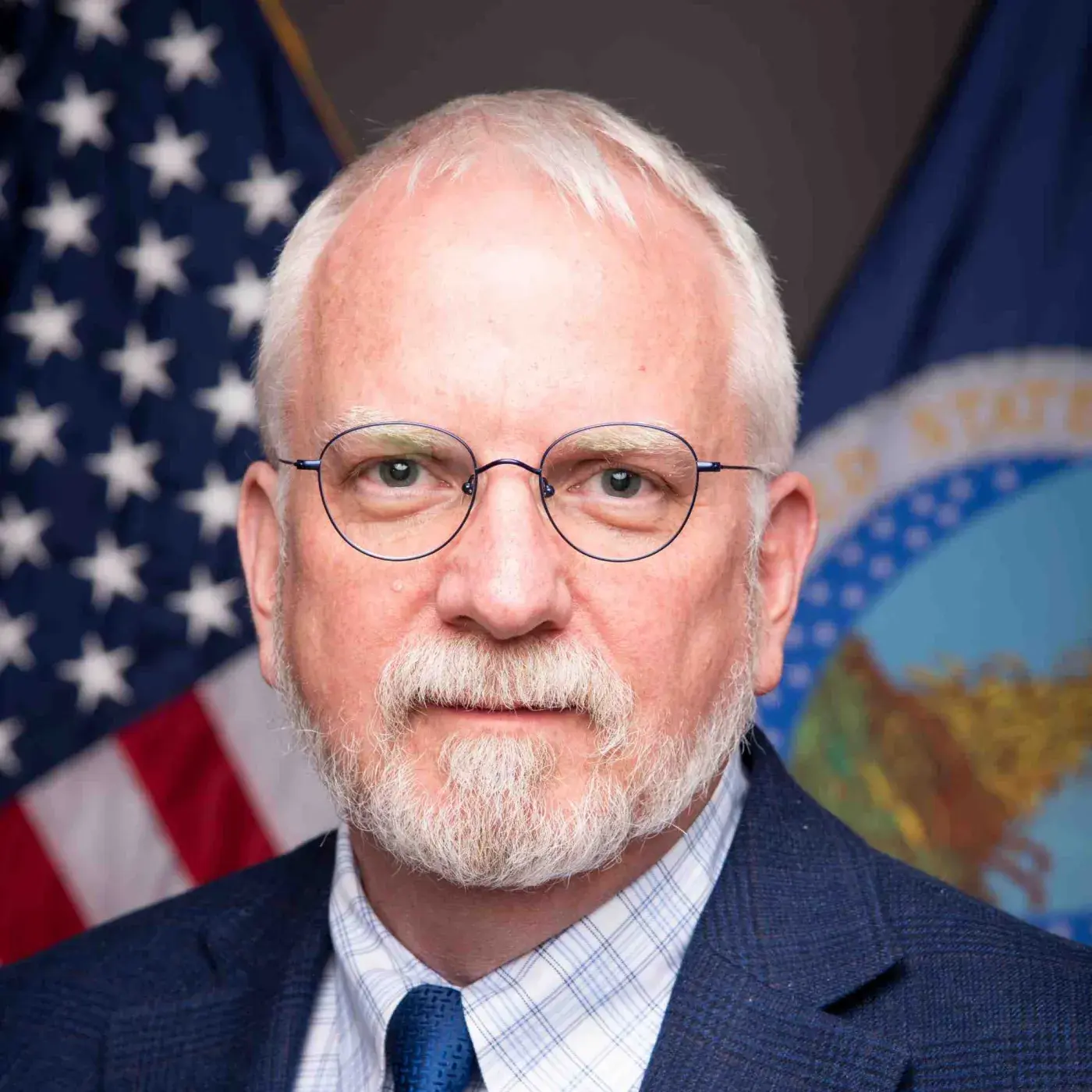 Headshot of Scott Marlow with flags in the background