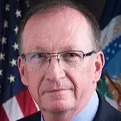 Headshot of William Cobb with flags in the background